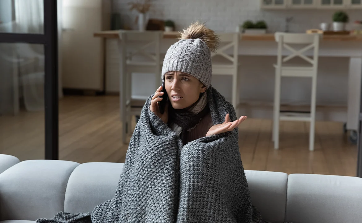 a woman in a knitted hat and scarf talking on a phone