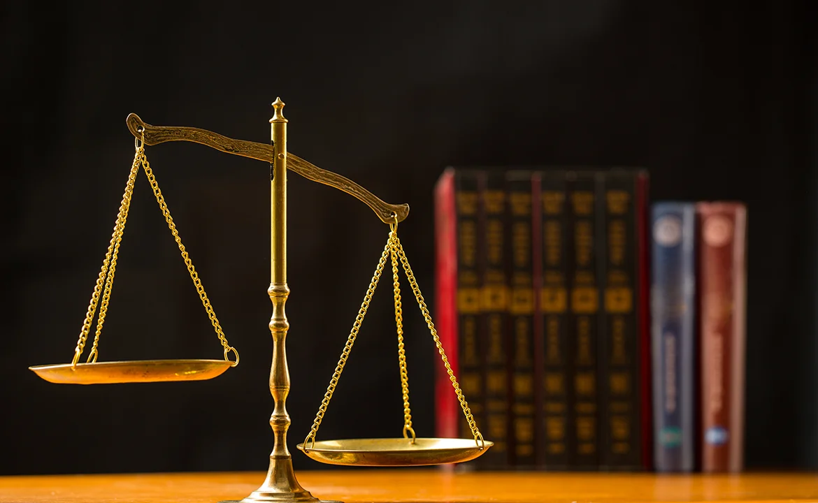 a gold scale with books in the background