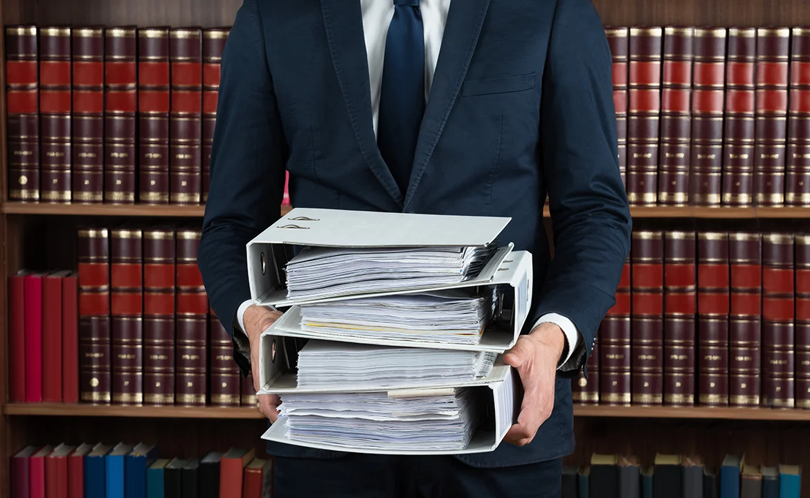 a man holding a stack law papers