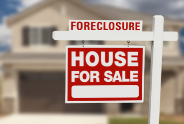 a sign board for a house sale is placed in front of the home